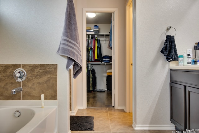 bathroom featuring tile patterned floors, a washtub, and vanity