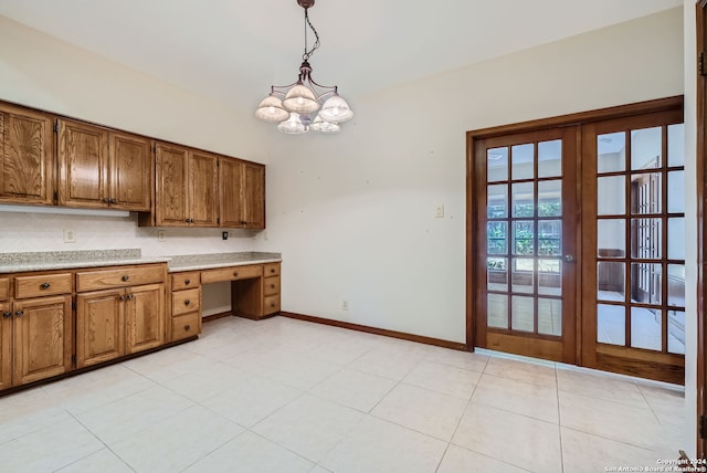 kitchen with light tile patterned floors, hanging light fixtures, a notable chandelier, and french doors