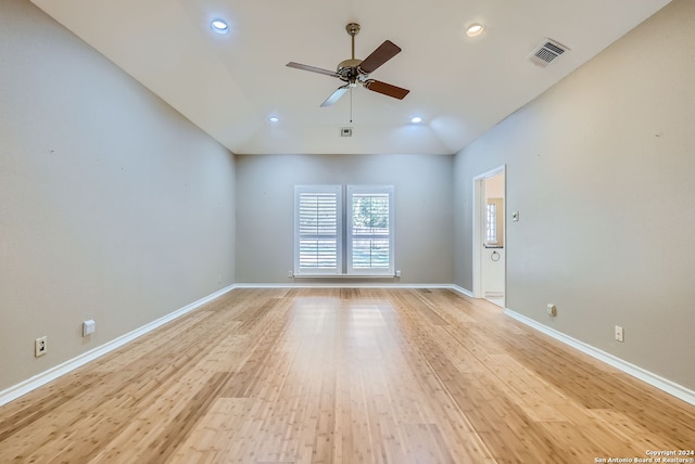 empty room with ceiling fan, light hardwood / wood-style floors, and vaulted ceiling