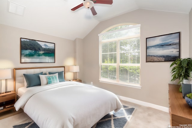 bedroom with ceiling fan, vaulted ceiling, and light carpet