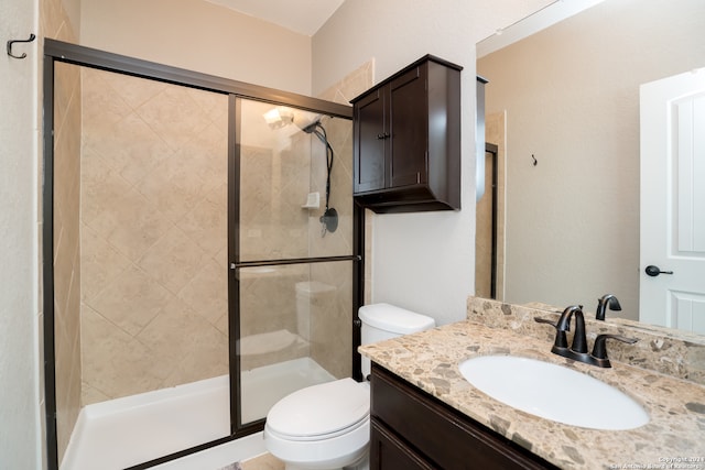 bathroom featuring an enclosed shower, toilet, and vanity