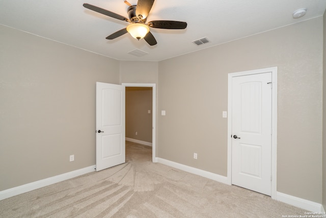 empty room with ceiling fan and light colored carpet