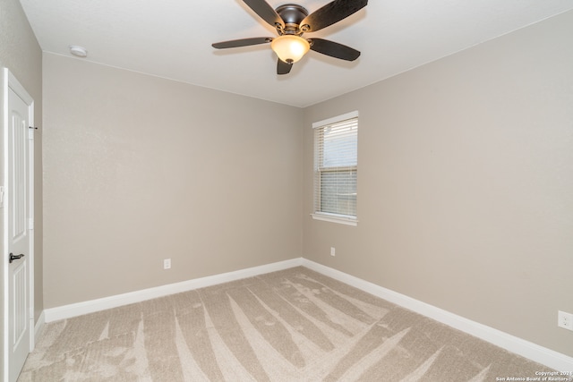 carpeted spare room featuring ceiling fan