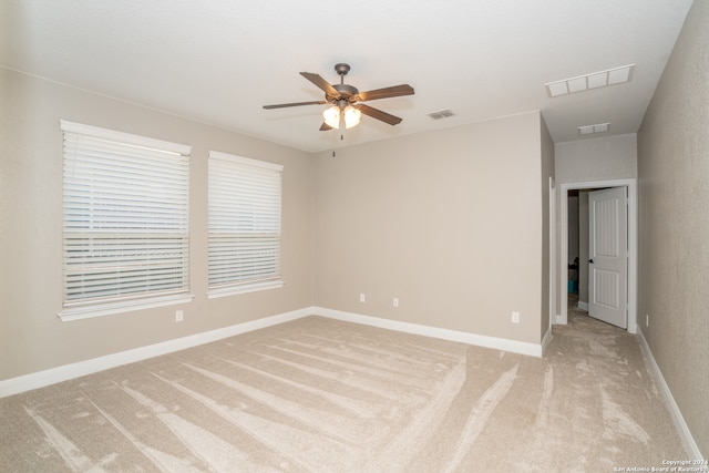 carpeted spare room featuring ceiling fan