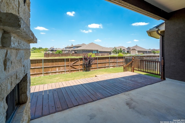 wooden terrace featuring a residential view and a fenced backyard