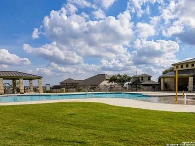 view of swimming pool featuring a lawn and a gazebo