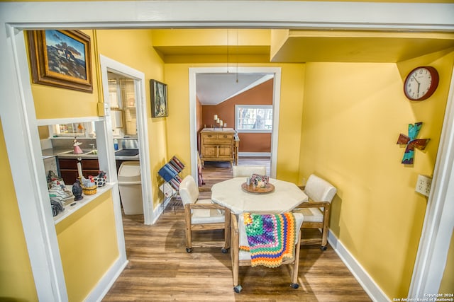 dining area featuring hardwood / wood-style floors and vaulted ceiling