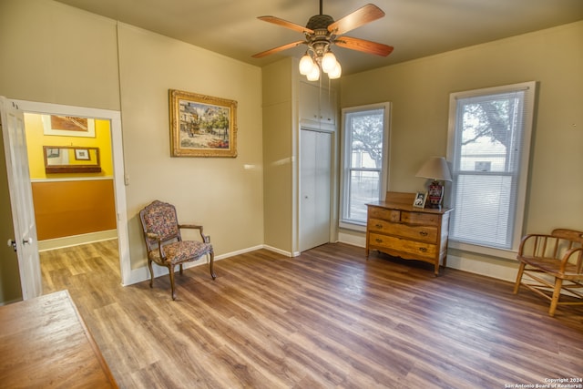 living area featuring hardwood / wood-style floors and ceiling fan