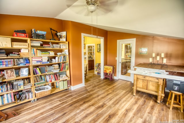 interior space featuring ceiling fan, vaulted ceiling, and wood-type flooring