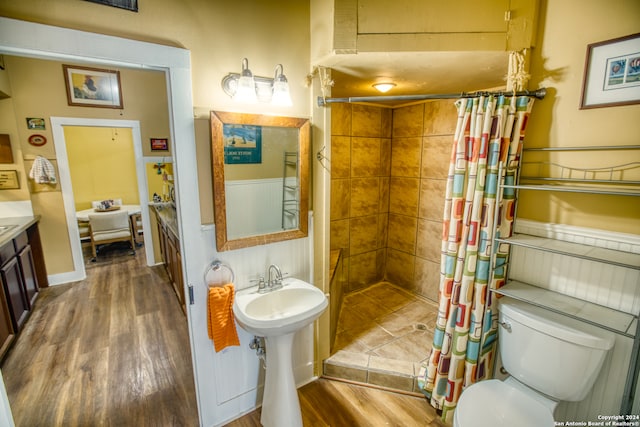 bathroom featuring wood-type flooring, curtained shower, and toilet