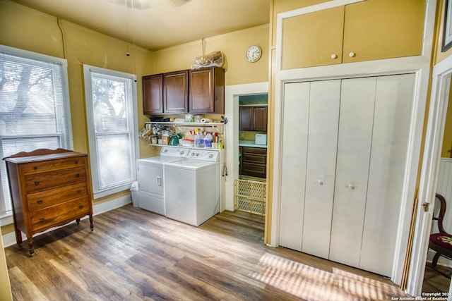 laundry area featuring light hardwood / wood-style flooring, cabinets, and separate washer and dryer