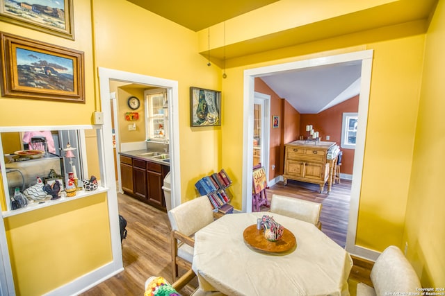 dining room with lofted ceiling and wood-type flooring