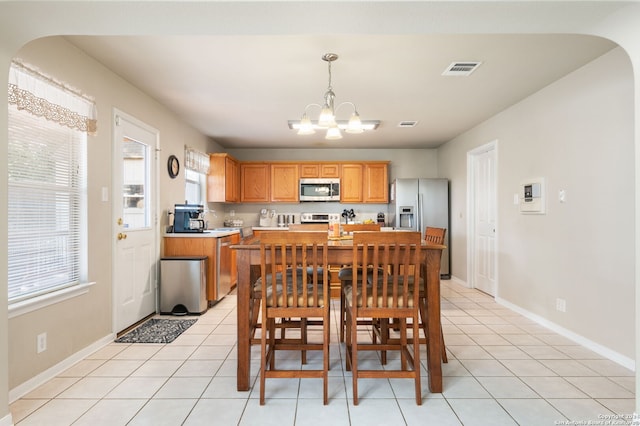 tiled dining space featuring a notable chandelier