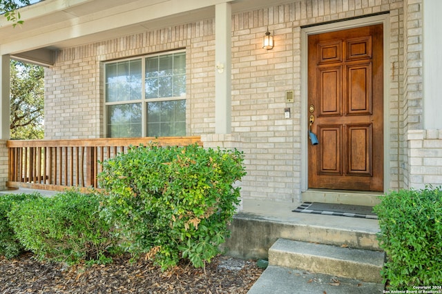 view of exterior entry featuring covered porch