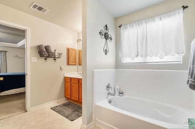 bathroom with tile patterned floors, a washtub, and vanity