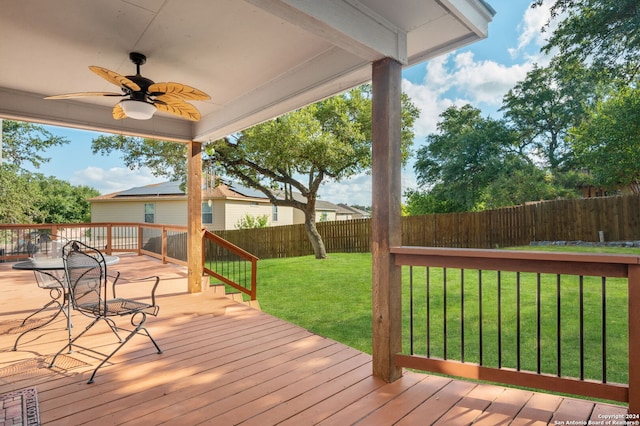 wooden deck with ceiling fan and a lawn