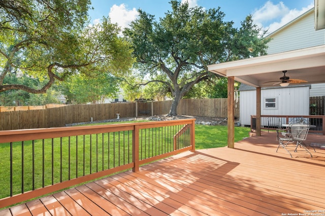 wooden deck featuring a lawn and ceiling fan