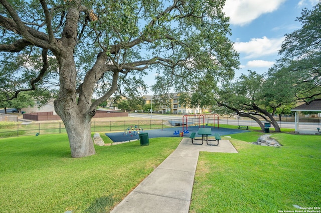 view of property's community featuring a lawn and a playground