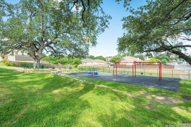 view of property's community featuring a lawn and a playground