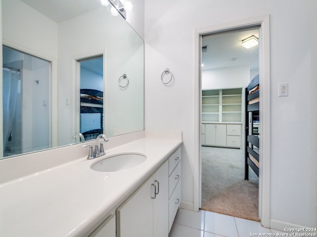 bathroom featuring vanity, a shower, and tile patterned flooring