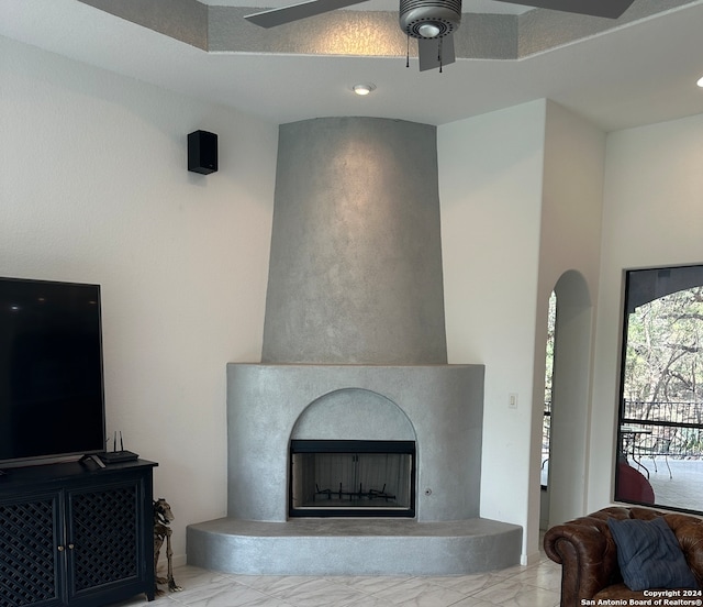 living room featuring ceiling fan and a large fireplace