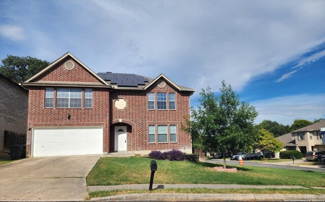 view of front of home with solar panels, a garage, and a front yard