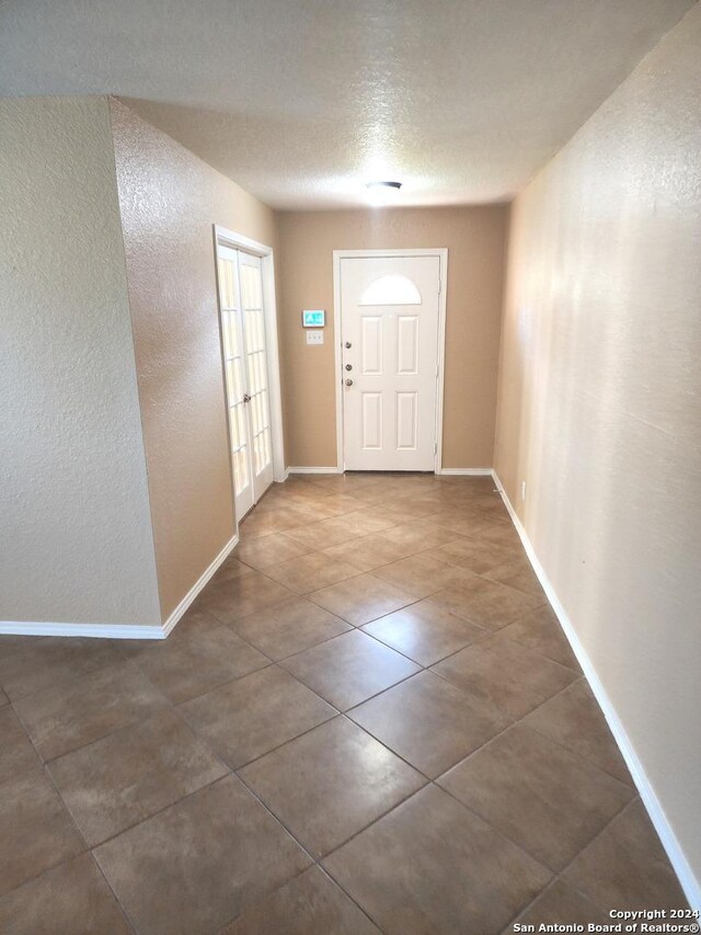 tiled spare room with a textured ceiling