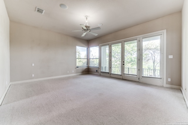 spare room with ceiling fan, french doors, and light carpet