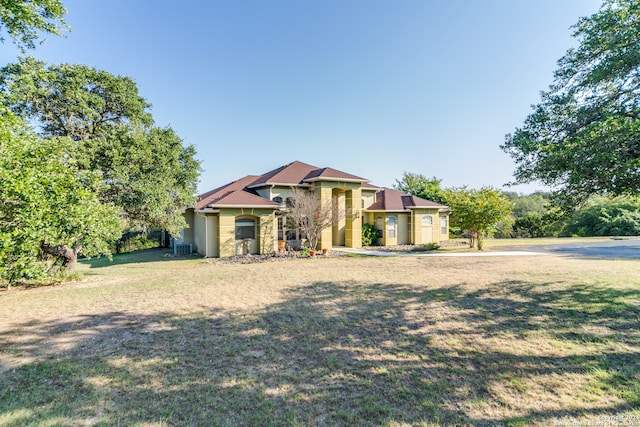 view of front of property with a front lawn and cooling unit