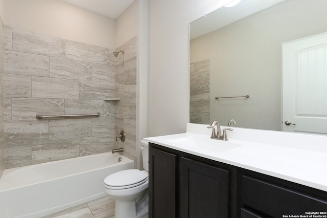 full bathroom with tiled shower / bath, vanity, and toilet