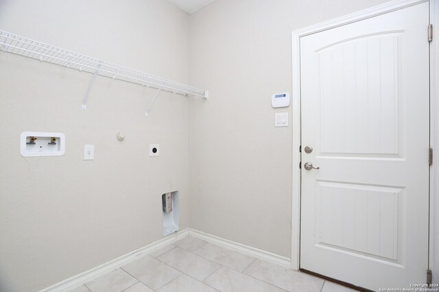 washroom featuring hookup for an electric dryer, hookup for a gas dryer, hookup for a washing machine, and light tile patterned floors