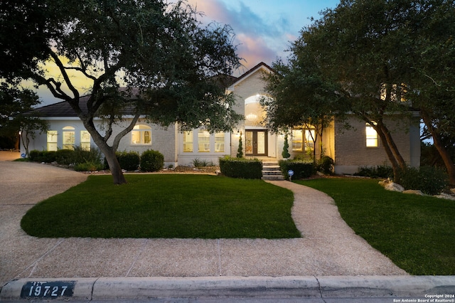 obstructed view of property with a yard