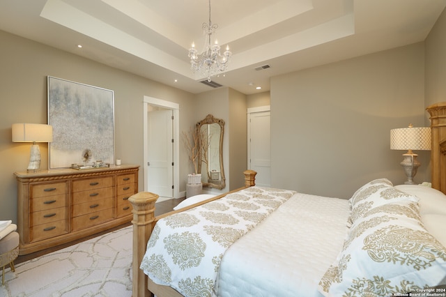 bedroom featuring a closet, a raised ceiling, and an inviting chandelier