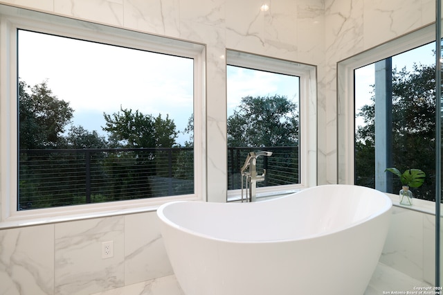 bathroom featuring a washtub, tile walls, and tile patterned floors