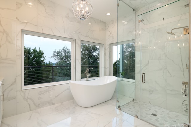 bathroom featuring tile walls, independent shower and bath, an inviting chandelier, and tile patterned floors