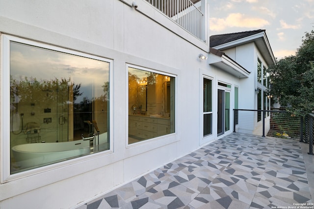 property exterior at dusk with a patio