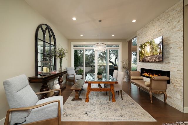 dining space with a notable chandelier, dark hardwood / wood-style flooring, and a fireplace