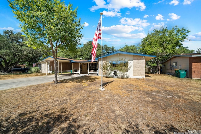 view of front facade featuring brick siding, an attached carport, and concrete driveway