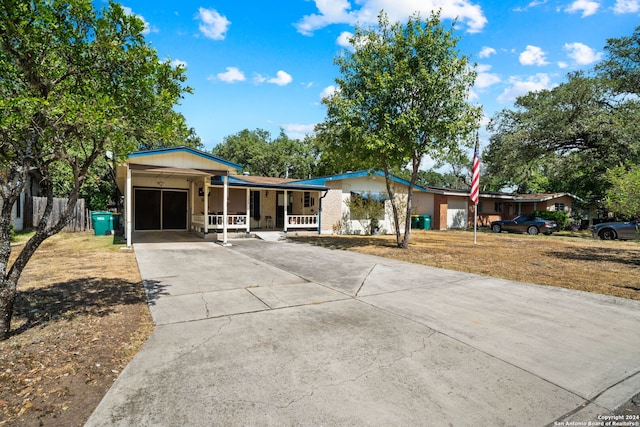 view of front of home featuring concrete driveway, a porch, brick siding, and an attached garage