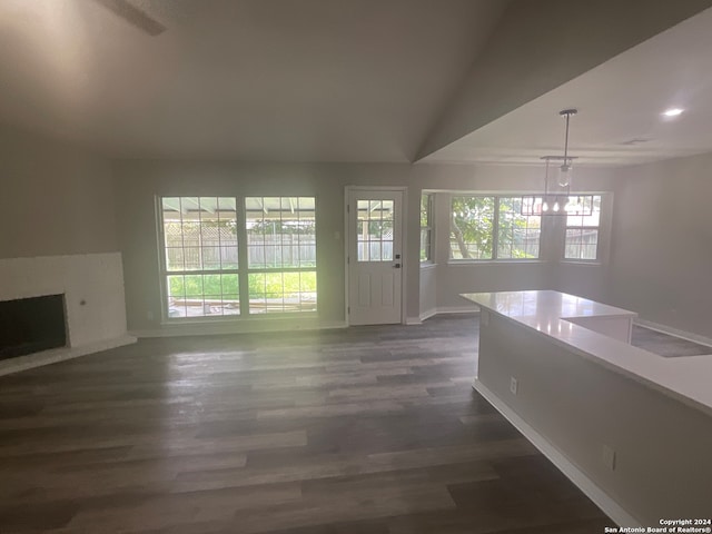 unfurnished living room featuring a chandelier, dark hardwood / wood-style floors, and lofted ceiling