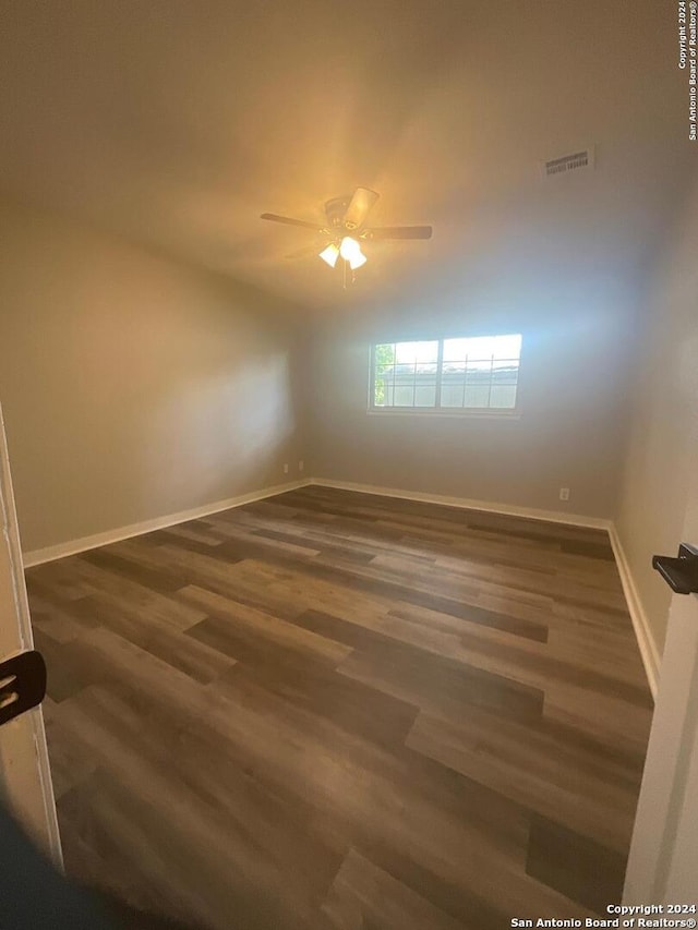 spare room featuring ceiling fan and dark wood-type flooring