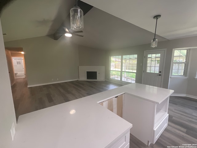 kitchen with pendant lighting, vaulted ceiling with beams, white cabinetry, and dark wood-type flooring