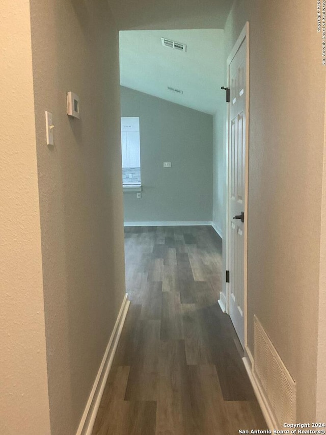 hall featuring dark hardwood / wood-style floors and vaulted ceiling