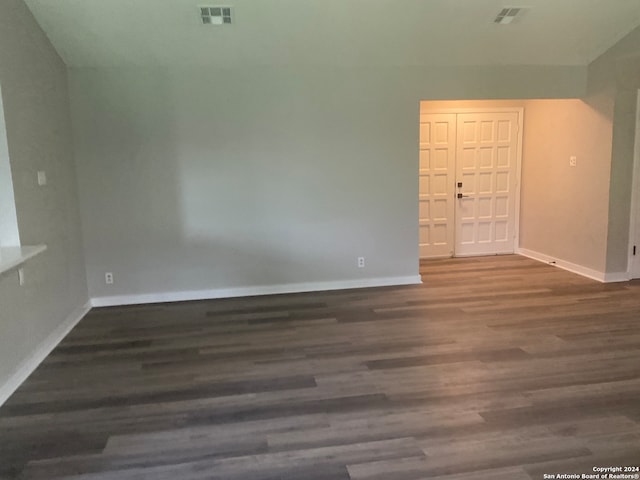 unfurnished room with dark wood-type flooring