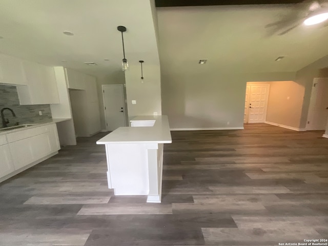 kitchen featuring sink, tasteful backsplash, dark hardwood / wood-style flooring, pendant lighting, and white cabinets