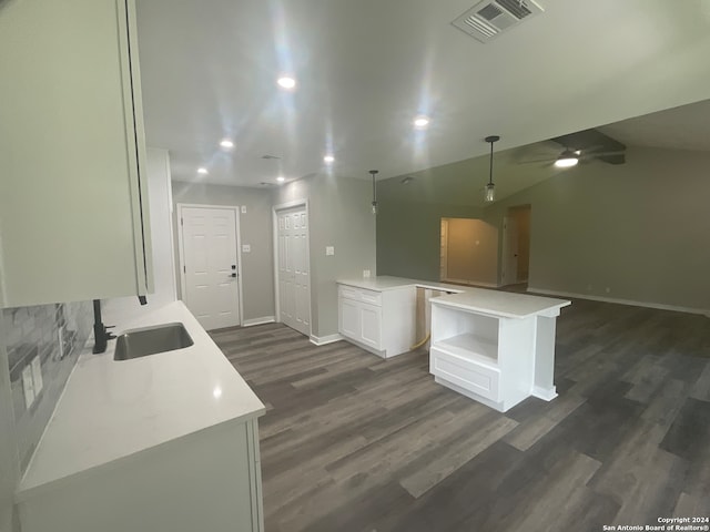 kitchen featuring a center island, sink, vaulted ceiling, dark hardwood / wood-style flooring, and white cabinetry