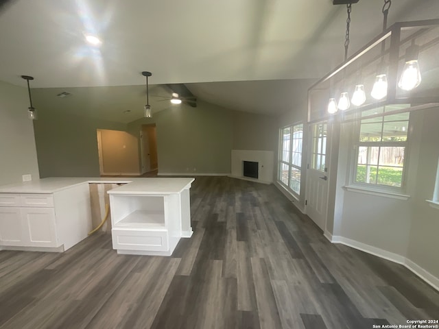 kitchen featuring a center island, vaulted ceiling, dark hardwood / wood-style floors, decorative light fixtures, and white cabinetry