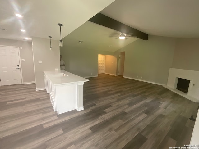 unfurnished living room featuring dark hardwood / wood-style flooring, lofted ceiling with beams, and ceiling fan