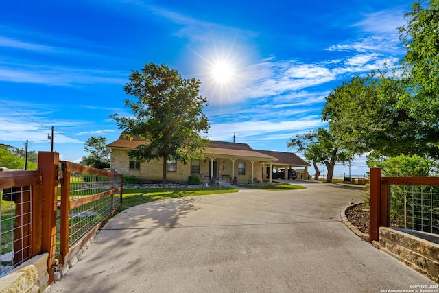 735 Hot Shot Ln, Mcqueeney, TX 78123 - view of front of home with a porch, fence, curved driveway, and a gate