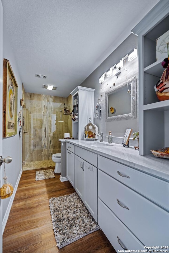 735 Hot Shot Ln, Mcqueeney, TX 78123 - bathroom featuring wood finished floors, toilet, vanity, visible vents, and a stall shower